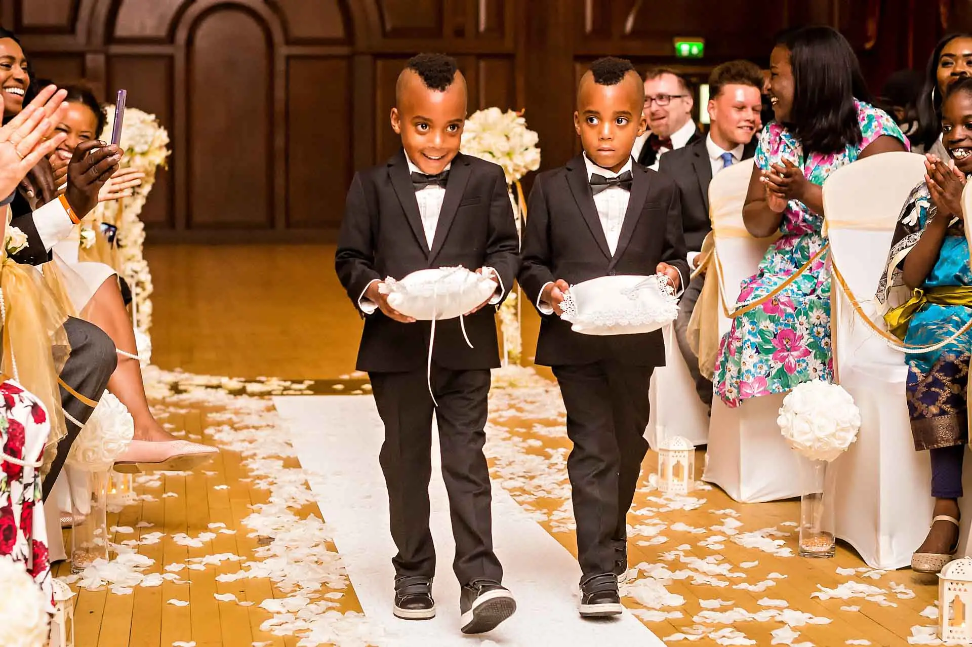  Zwei Pagen, die Ringe bei der Hochzeit in Porchester Hall den Gang hinunter tragen