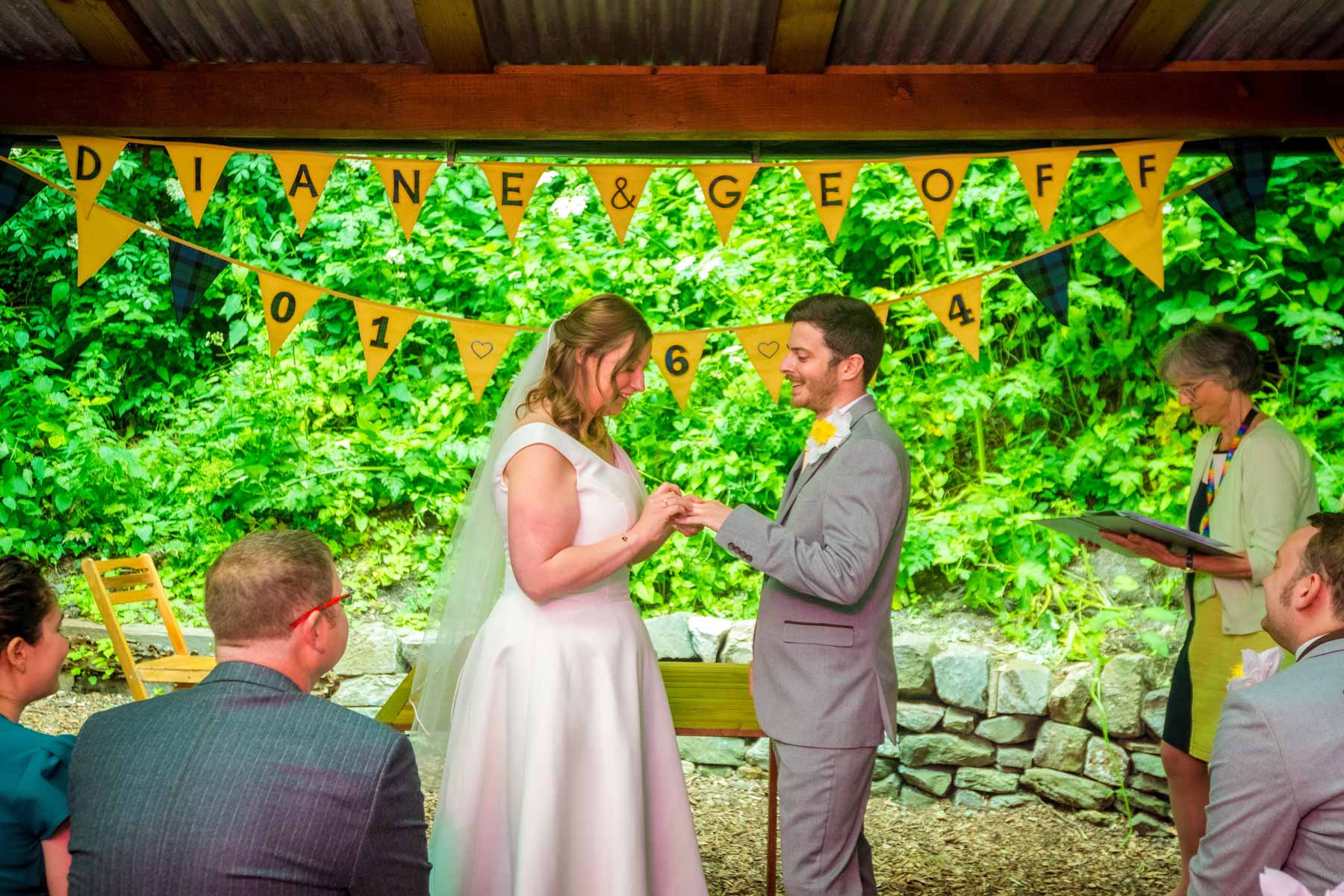 The bride places the ring of the groom's finger in the Underwood Centre at Arnos Vale.