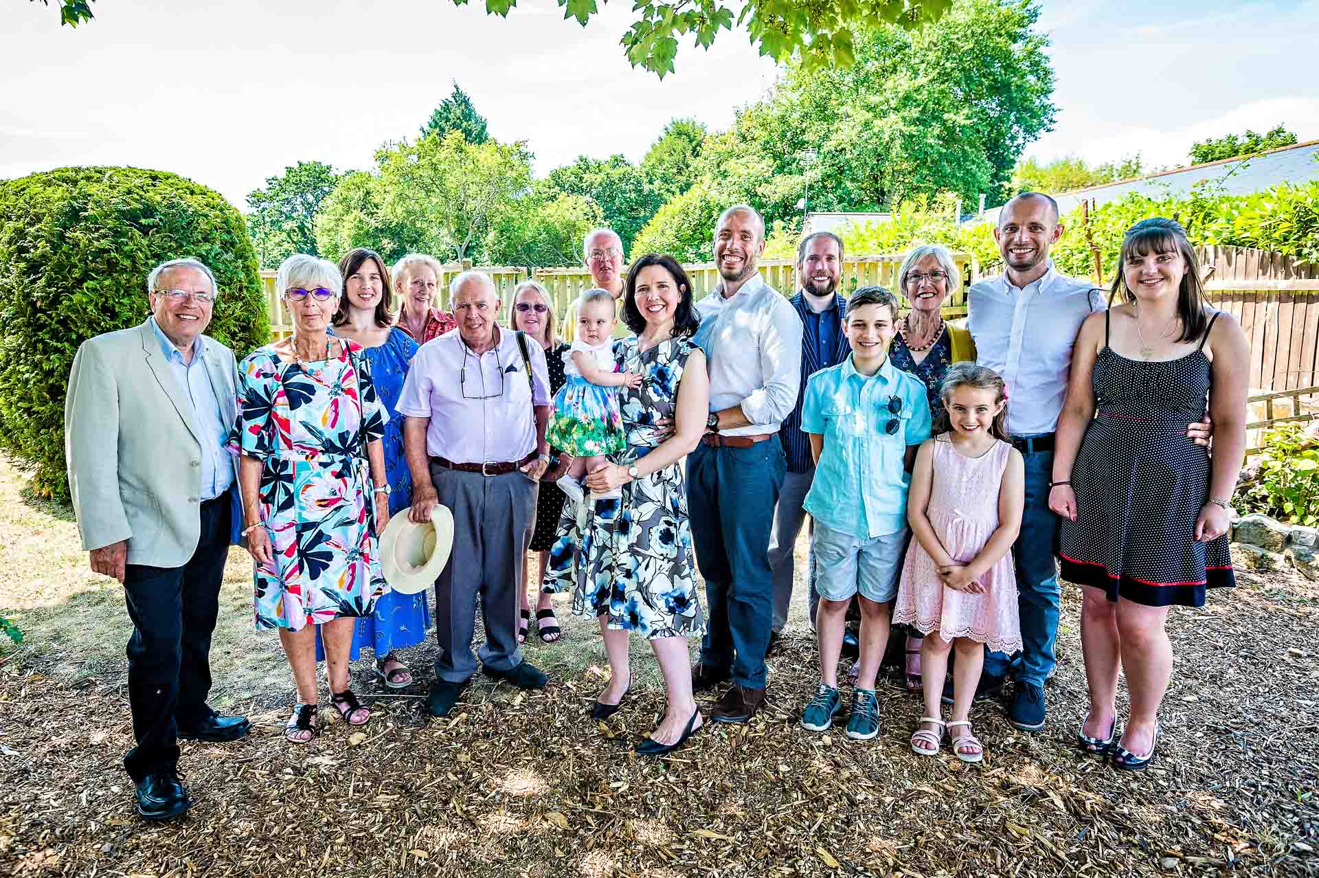 Group photo of family under tress at baby naming ceremony