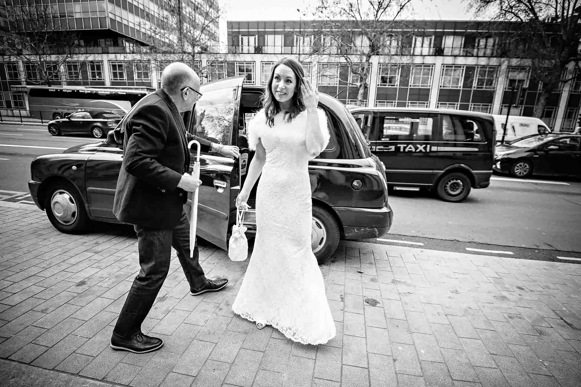 Bride leaving black taxi as father closes the door